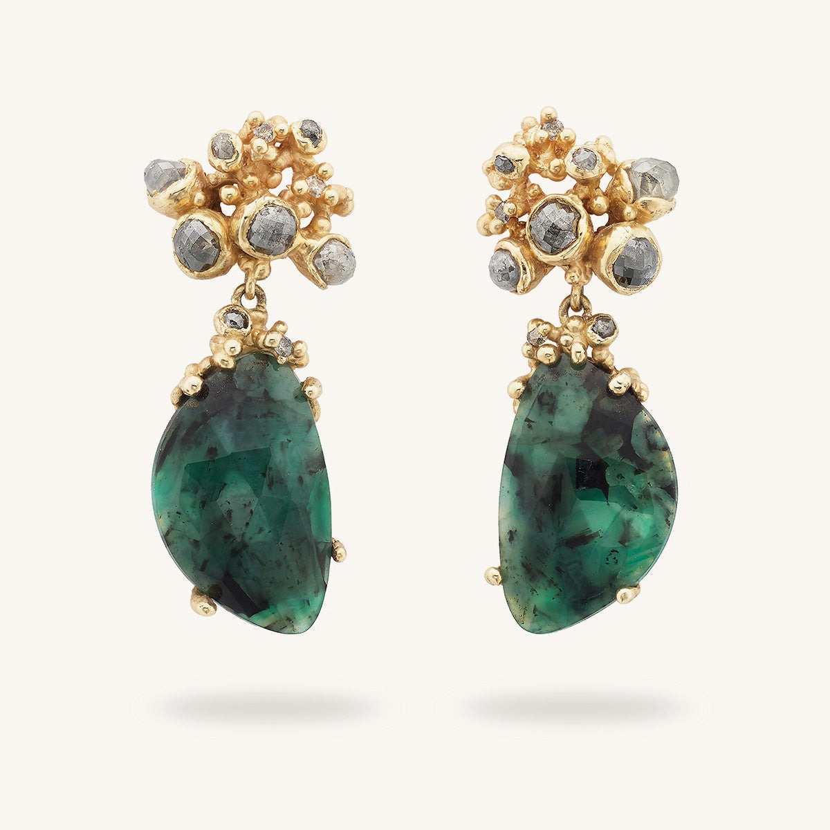 One-of-a-kind, handcrafted statement drop earrings featuring speckled rose cut emeralds suspended from an asymmetric cluster of grey diamonds. 