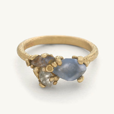 Asymmetric cluster ring featuring three contrasting gemstones set amongst golden barnacle details. Handcrafted in London with recycled gold and responsibly sourced gemstones. 