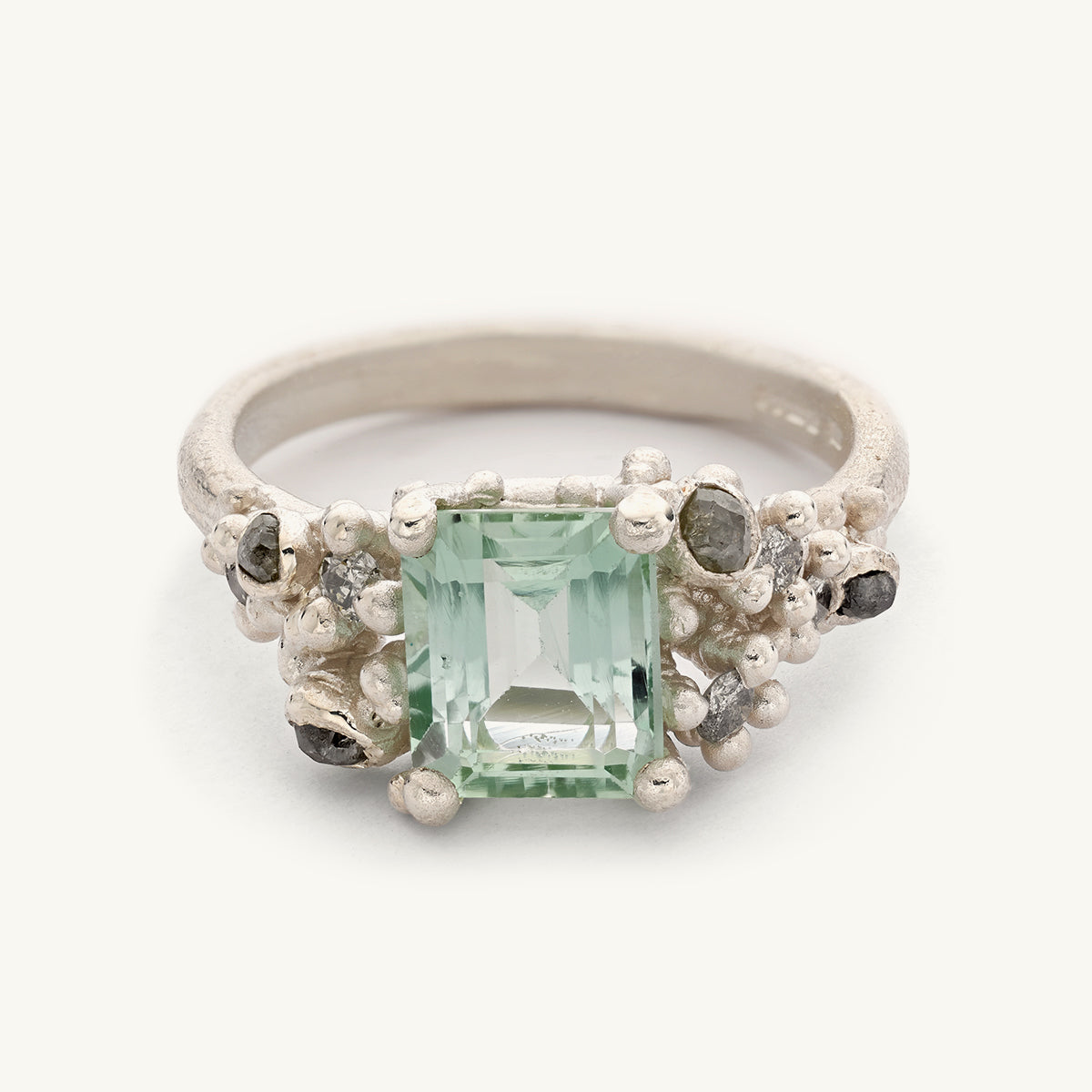 9ct white gold ring with an emerald cut mint green tourmaline and asymmetric clusters of mixed cut diamonds. Handmade in London with recycled gold and responsibly sourced gemstones. 