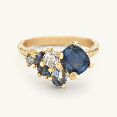 A unique one-of-a-kind alternative engagement ring with sapphire and diamonds set in an asymmetric tapering cluster. 