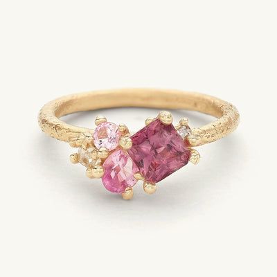 A unique engagement ring with an asymmetric cluster of pink sapphires and diamonds. 