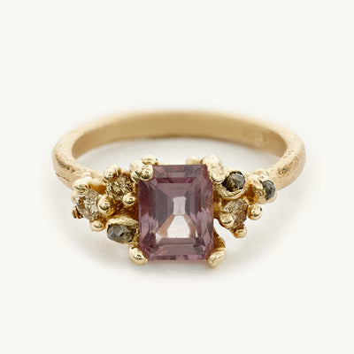One-of-a-kind ring with an emerald cut pink sapphire and clusters of champagne diamonds. 