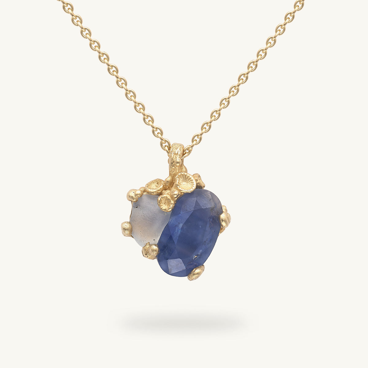 Recycled gold necklace with barnacle details and a semi cut and raw sapphire. Handcrafted in London with recycled gold and responsibly sourced gemstones. 